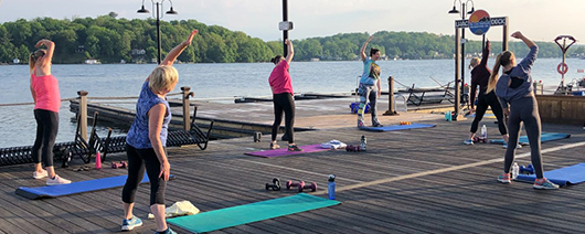 Group of women side stretching on the Nolan's Point boardwalk