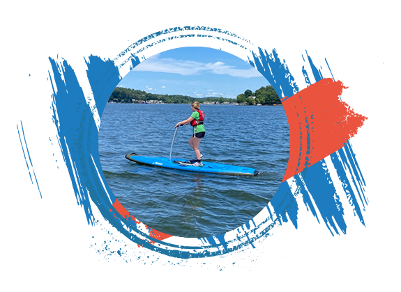 Man waving while riding pedalboard on Lake Hopatcong