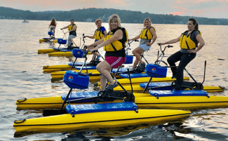 Women riding pedalboards on Lake Hopatcong