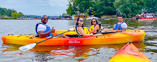 Young woman smiling as she paddles her single yellow kayak on Lake Hopatcong NJ